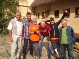 Eine Gruppe Männer auf einem Hof, einige in orangefarbenen T-Shirts