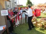 Ein Chor singt im Freien unter Leitung eines Dirigenten