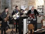 Eine Band mit Saxofon und Gitarren spielt in der Kirche