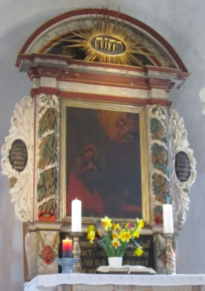 Die Partnerkerze auf dem Altar in Böllberg vor dem Altarbild, daneben Osterglocken