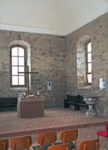 Innenraum der Wörmlitzer Kirche mit Rundbogenfenstern und Altar